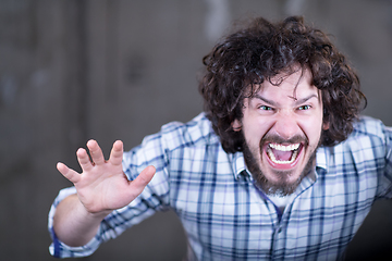 Image showing casual businessman screaming in front of a concrete wall