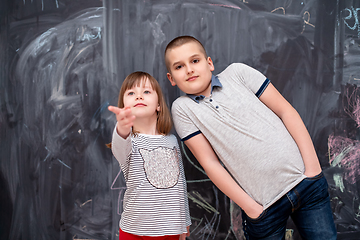 Image showing boy and little girl standing in front of chalkboard