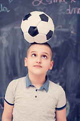 Image showing happy boy holding a soccer ball on his head