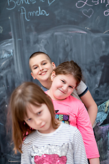 Image showing group of kids standing in front of chalkboard