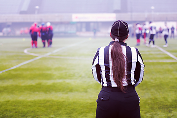 Image showing rear view of female american football referee