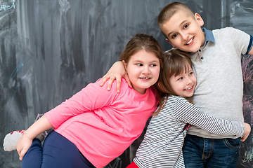 Image showing group of kids hugging in front of chalkboard