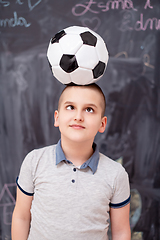 Image showing happy boy holding a soccer ball on his head