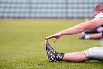 Image showing american football players stretching and warming up