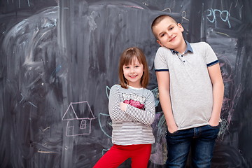 Image showing boy and little girl standing in front of chalkboard