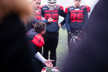 Image showing american football player discussing strategy with his team