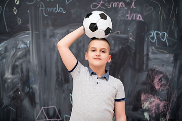 Image showing happy boy holding a soccer ball on his head