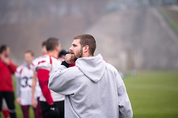 Image showing american football players stretching and warming up