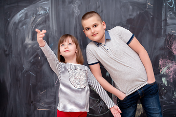 Image showing boy and little girl standing in front of chalkboard