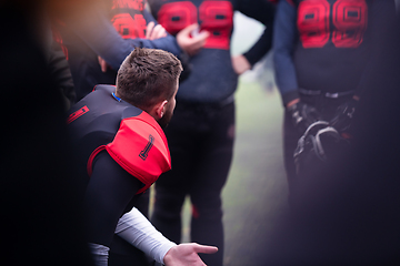 Image showing american football player discussing strategy with his team