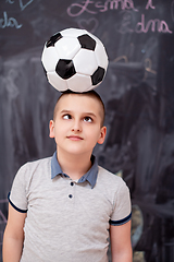 Image showing happy boy holding a soccer ball on his head