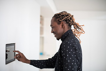 Image showing African man using smart home screen