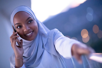 Image showing Young Muslim woman on  street at night using phone