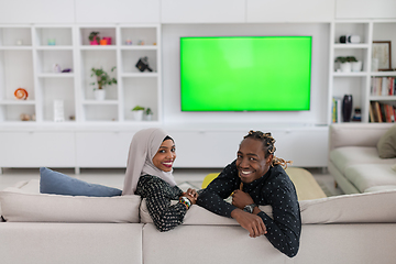 Image showing African Couple Sitting On Sofa Watching TV Together