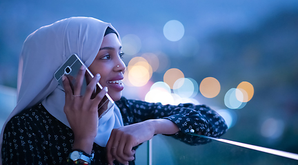 Image showing Young Muslim woman on  street at night using phone