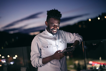 Image showing Young  Afro man on  street at night using phone