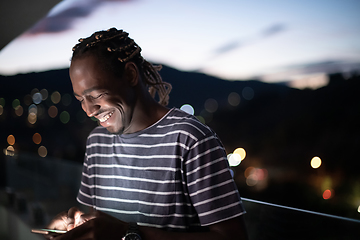 Image showing Young  Afro man on  street at night using phone