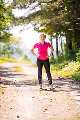Image showing portrait of young woman jogging on sunny day at nature