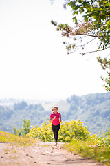 Image showing young woman jogging on sunny day at nature
