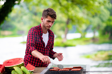 Image showing Man cooking tasty food on barbecue grill