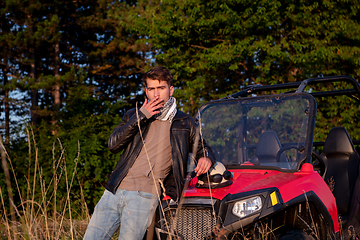 Image showing young man taking a break from driving a off road buggy car