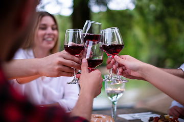 Image showing happy friends toasting red wine glass during french dinner party