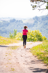 Image showing young woman jogging on sunny day at nature