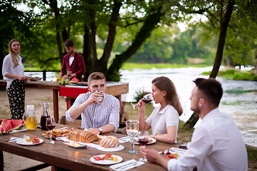 Image showing happy friends having picnic french dinner party outdoor