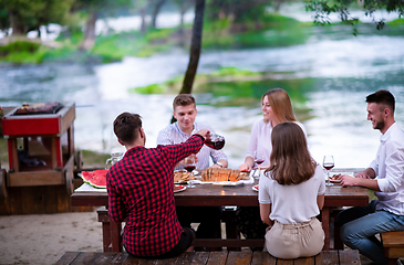 Image showing happy friends having picnic french dinner party outdoor