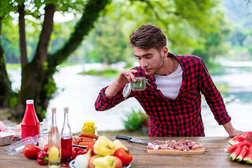 Image showing Man putting spices on raw meat  for barbecue grill