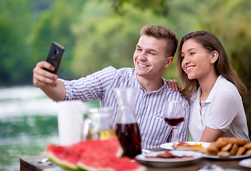 Image showing young couple taking selfie on french dinner party outdoor