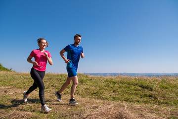 Image showing young couple jogging on sunny day at summer mountain