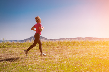 Image showing young woman jogging on sunny day at summer mountain