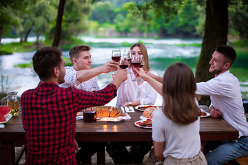 Image showing happy friends toasting red wine glass during french dinner party