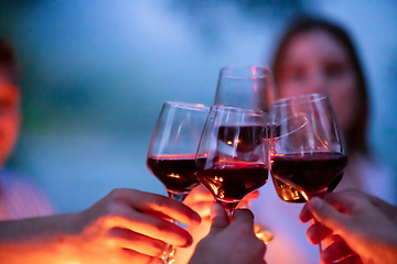 Image showing friends toasting red wine glass during french dinner party outdo