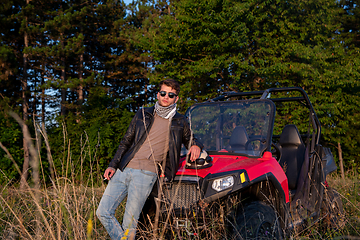 Image showing young man taking a break from driving a off road buggy car