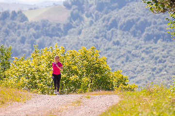 Image showing young woman jogging on sunny day at nature