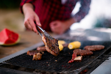 Image showing Man cooking tasty food on barbecue grill