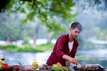 Image showing Man cooking tasty food on barbecue grill