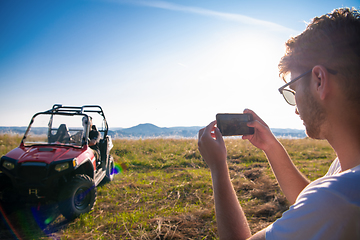 Image showing two young men having fun while driving a off road buggy car