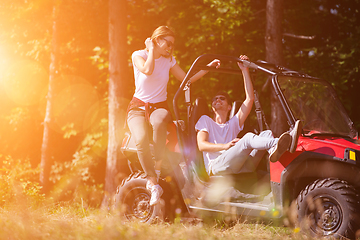 Image showing young couple driving a off road buggy car