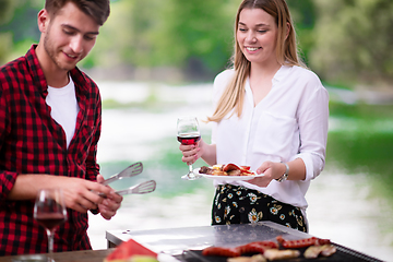 Image showing happy couple having picnic french dinner party outdoor