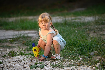 Image showing Little blonde girl with a water pistol