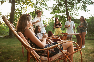 Image showing Happy friends eating and drinking beers at barbecue dinner on sunset time