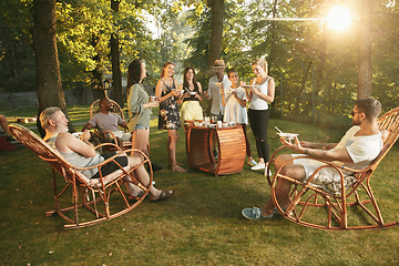 Image showing Happy friends eating and drinking beers at barbecue dinner on sunset time