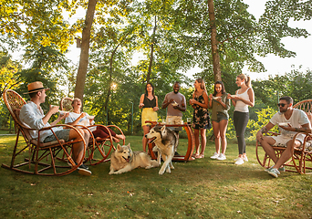 Image showing Happy friends eating and drinking beers at barbecue dinner on sunset time