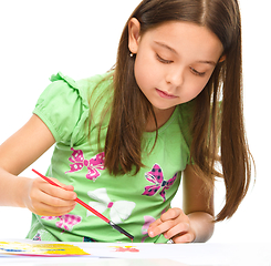 Image showing Little girl is painting with gouache