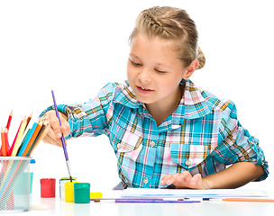 Image showing Little girl is painting with gouache