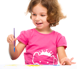 Image showing Little girl is painting with gouache