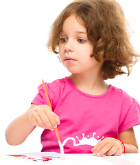 Image showing Little girl is painting with gouache